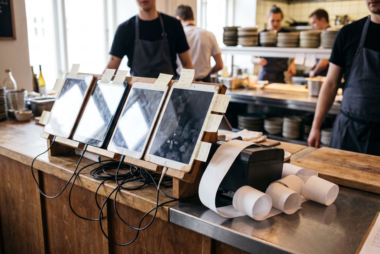 Four tablets and a receipt printer on a restaurant counter